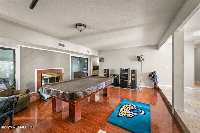 2438 Sylvan Chase Dr, Orange Park, FL 32073 - recreation room with a textured ceiling, wood finished floors, a brick fireplace, billiards, and baseboards