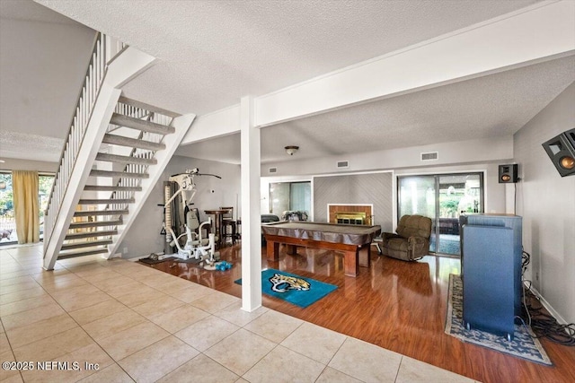 2438 Sylvan Chase Dr, Orange Park, FL 32073 - workout area featuring tile patterned flooring, a textured ceiling, and a glass covered fireplace