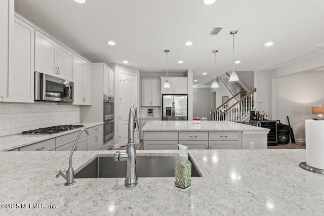 kitchen featuring stainless steel appliances, a center island, recessed lighting, light stone counters, and decorative backsplash