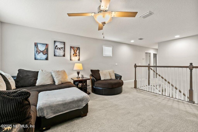 carpeted living area featuring recessed lighting, ceiling fan, a textured ceiling, and baseboards