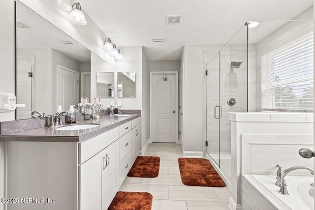 full bathroom with a shower stall, a bath, double vanity, tile patterned floors, and baseboards