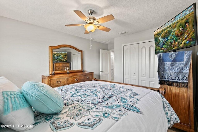 bedroom featuring a closet, a textured ceiling, and a ceiling fan