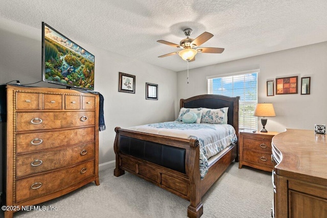 bedroom with light colored carpet, a textured ceiling, and a ceiling fan