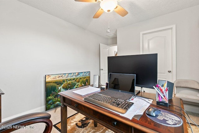 office area featuring ceiling fan, a textured ceiling, and baseboards