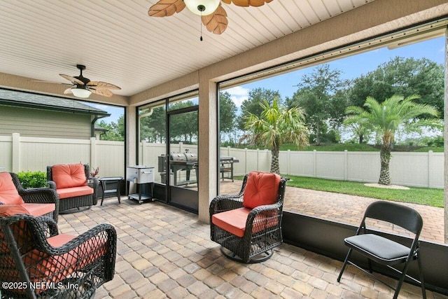 sunroom featuring a ceiling fan and healthy amount of natural light