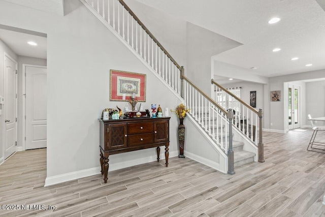 stairs featuring wood finished floors, baseboards, and recessed lighting