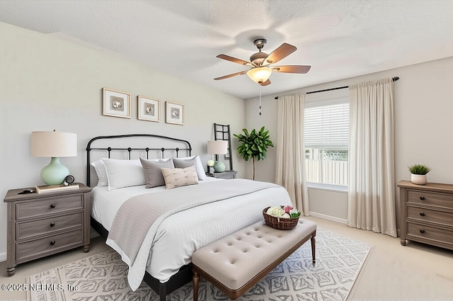 bedroom featuring light colored carpet, baseboards, and a ceiling fan