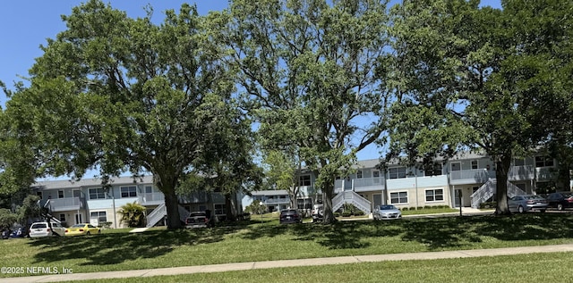 view of community with stairway and a yard