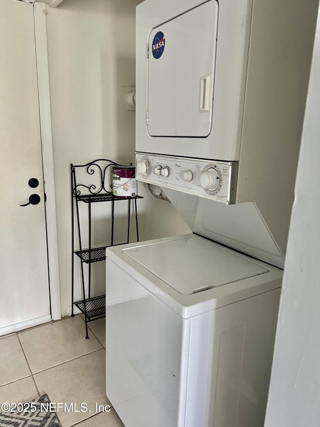washroom with stacked washer and clothes dryer and light tile patterned flooring
