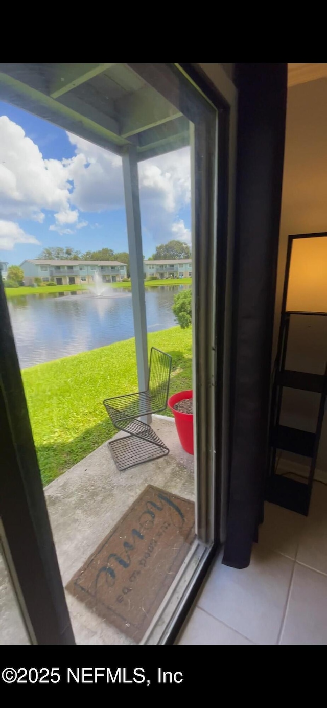 doorway with a water view and tile patterned floors