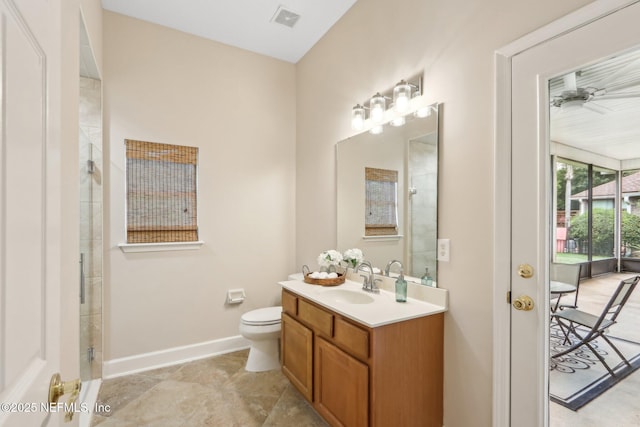2214 Links Dr, Fleming Island, FL 32003 - bathroom featuring vanity, toilet, tiled shower, baseboards, and a ceiling fan