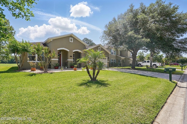 4956 Cypress Links Blvd, Elkton, FL 32033 - view of front facade with stucco siding, driveway, an attached garage, and a front yard
