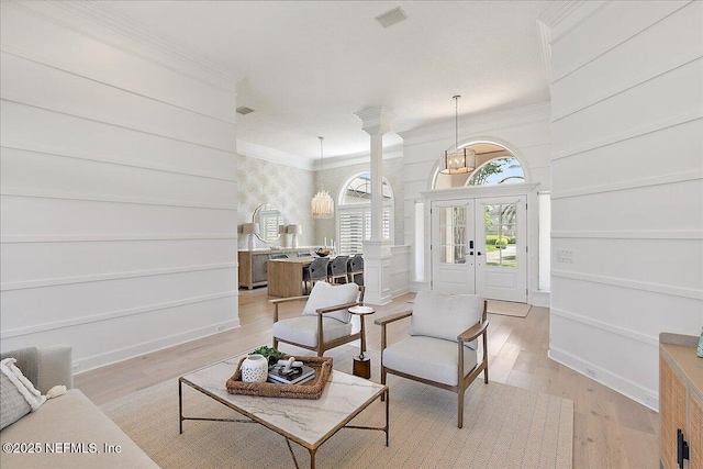 201 Royal Tern Rd N, Ponte Vedra Beach, FL 32082 - living room with decorative columns, crown molding, light wood-style flooring, baseboards, and a chandelier