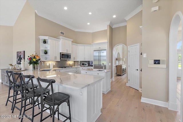 201 Royal Tern Rd N, Ponte Vedra Beach, FL 32082 - kitchen with appliances with stainless steel finishes, a sink, a peninsula, open shelves, and a high ceiling