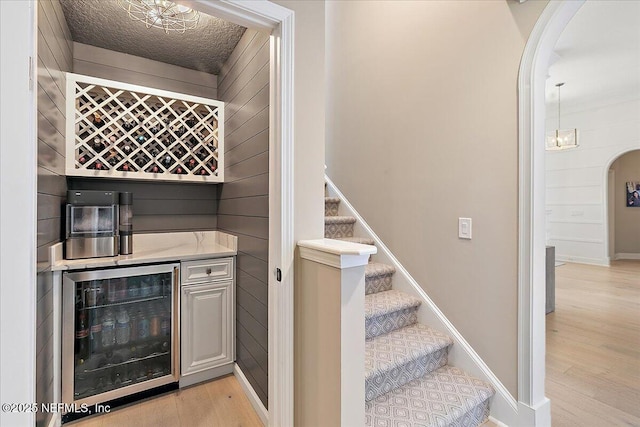 201 Royal Tern Rd N, Ponte Vedra Beach, FL 32082 - indoor dry bar with beverage cooler, arched walkways, light wood-style flooring, stairway, and baseboards