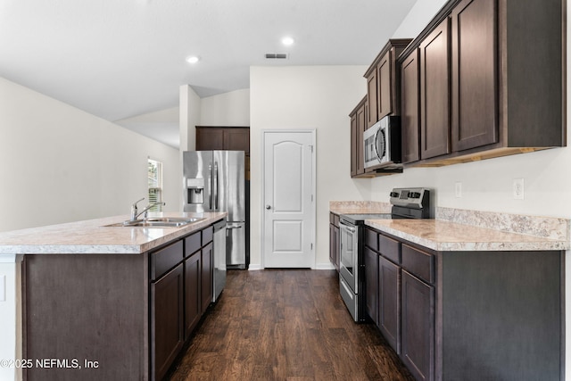 8244 Meadow Walk Ln, Jacksonville, FL 32256 - kitchen with appliances with stainless steel finishes, a sink, dark brown cabinetry, lofted ceiling, and a kitchen island with sink