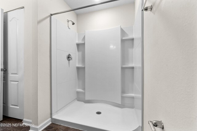 8244 Meadow Walk Ln, Jacksonville, FL 32256 - bathroom with a shower stall, wood finished floors, baseboards, and a textured wall