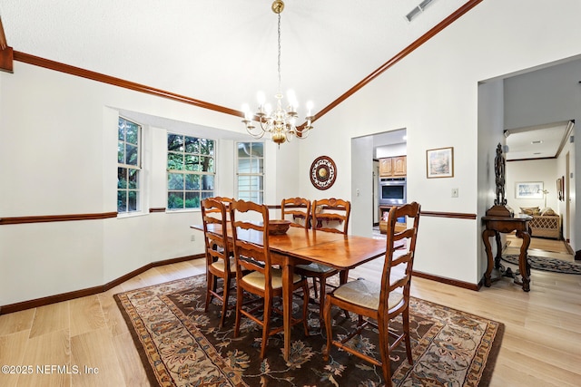 1917 Lakeside Dr S, Fernandina Beach, FL 32034 - dining space with crown molding, a chandelier, vaulted ceiling, light wood-style floors, and baseboards