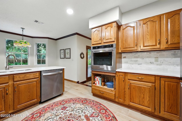 1917 Lakeside Dr S, Fernandina Beach, FL 32034 - kitchen with appliances with stainless steel finishes, a sink, brown cabinetry, crown molding, and recessed lighting