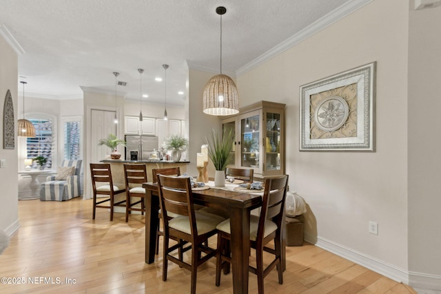 95050 Barclay Pl Unit 5B, Fernandina Beach, FL 32034 - dining area featuring light wood-style floors, baseboards, crown molding, and a textured ceiling