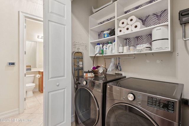 95050 Barclay Pl Unit 5B, Fernandina Beach, FL 32034 - laundry area featuring washing machine and clothes dryer, light tile patterned floors, and baseboards