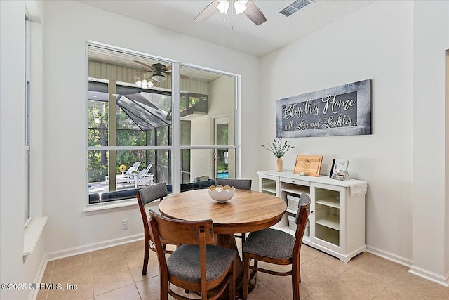dining room featuring ceiling fan, light tile patterned floors, and baseboards