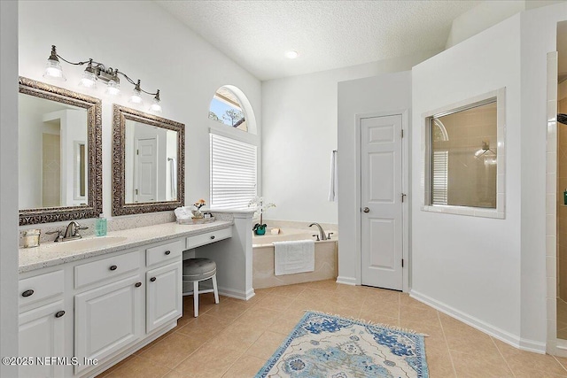 bathroom featuring a textured ceiling, tile patterned flooring, a tile shower, a garden tub, and vanity