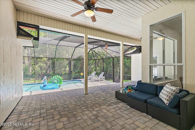 view of patio featuring a ceiling fan, an outdoor pool, and glass enclosure