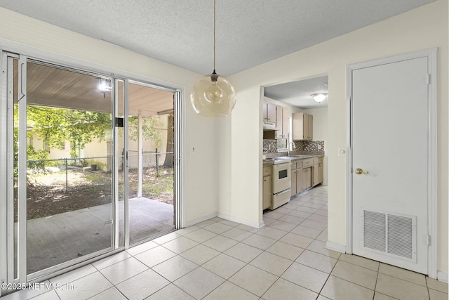 11437 Ricky Way, Jacksonville, FL 32223 - unfurnished dining area featuring light tile patterned flooring, baseboards, a textured ceiling, and a sink