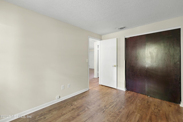 11437 Ricky Way, Jacksonville, FL 32223 - unfurnished bedroom with wood finished floors, baseboards, a closet, and a textured ceiling