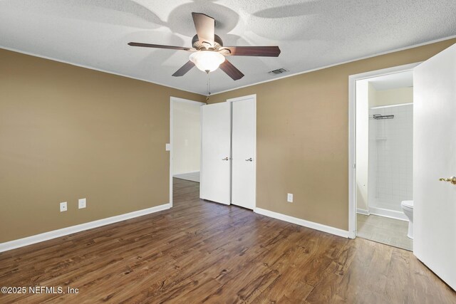 11437 Ricky Way, Jacksonville, FL 32223 - unfurnished bedroom featuring wood finished floors, baseboards, connected bathroom, ceiling fan, and a textured ceiling
