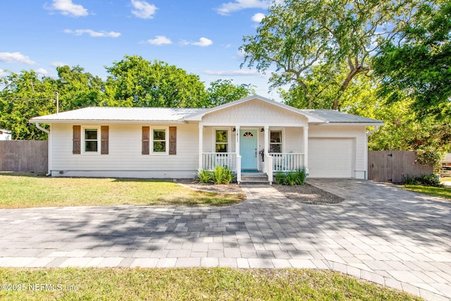1411 Leon St, Fernandina Beach, FL 32034 - ranch-style home featuring covered porch, a garage, decorative driveway, and metal roof