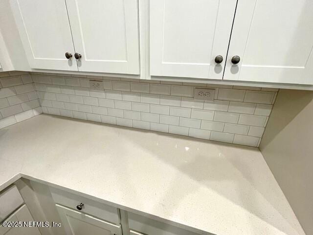 detailed view of white cabinets and decorative backsplash