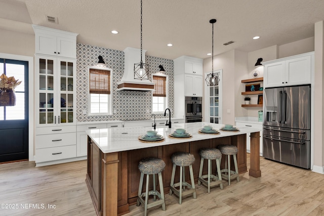 37 High Ridge Pt, Ponte Vedra, FL 32081 - kitchen featuring stainless steel appliances, open shelves, light countertops, light wood-style floors, and white cabinetry