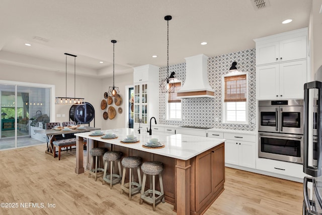 37 High Ridge Pt, Ponte Vedra, FL 32081 - kitchen featuring custom range hood, appliances with stainless steel finishes, light wood-style flooring, white cabinets, and recessed lighting