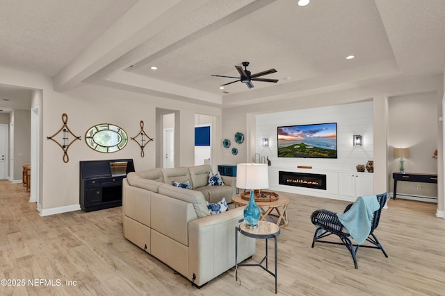 37 High Ridge Pt, Ponte Vedra, FL 32081 - living room featuring a raised ceiling, light wood-style floors, a textured ceiling, a glass covered fireplace, and ceiling fan