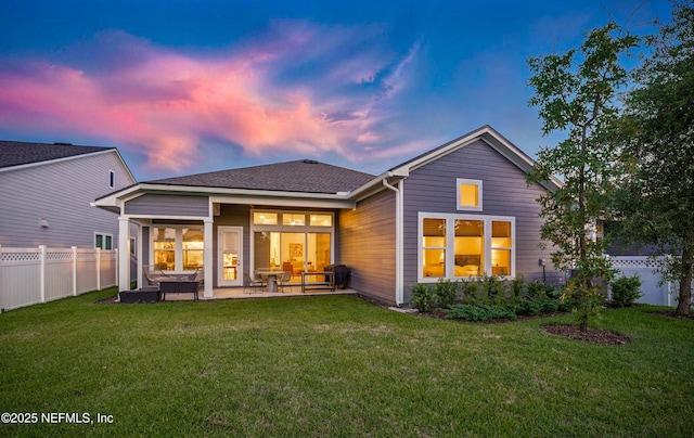 back of house at dusk featuring a patio