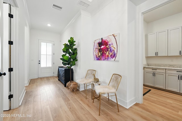 foyer entrance with crown molding, light wood finished floors, baseboards, and recessed lighting