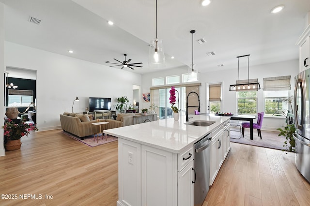 kitchen featuring stainless steel appliances, a sink, white cabinets, plenty of natural light, and recessed lighting