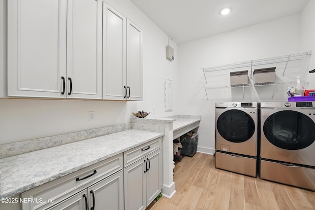 laundry room with washer and clothes dryer, cabinet space, light wood finished floors, recessed lighting, and baseboards