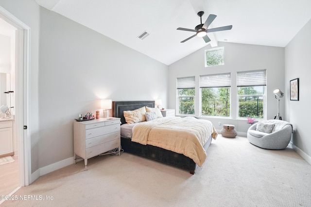 bedroom with vaulted ceiling, light carpet, baseboards, ceiling fan, and ensuite bath