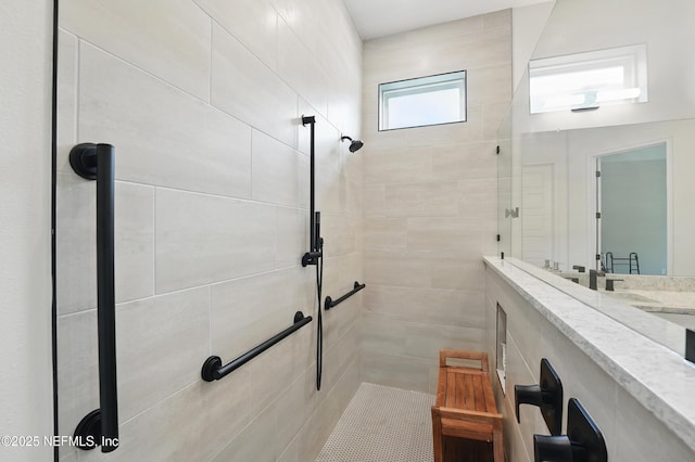 bathroom featuring a tile shower and vanity