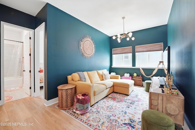 living area with a chandelier, wood finished floors, and vaulted ceiling