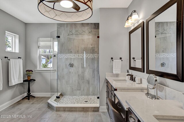 252 Pine Haven Dr, Saint Johns, FL 32259 - bathroom featuring tiled shower, baseboards, double vanity, and wood finished floors