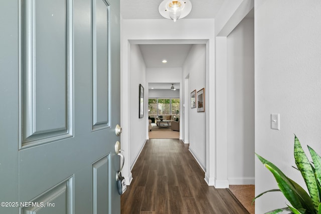 corridor with baseboards and dark wood finished floors