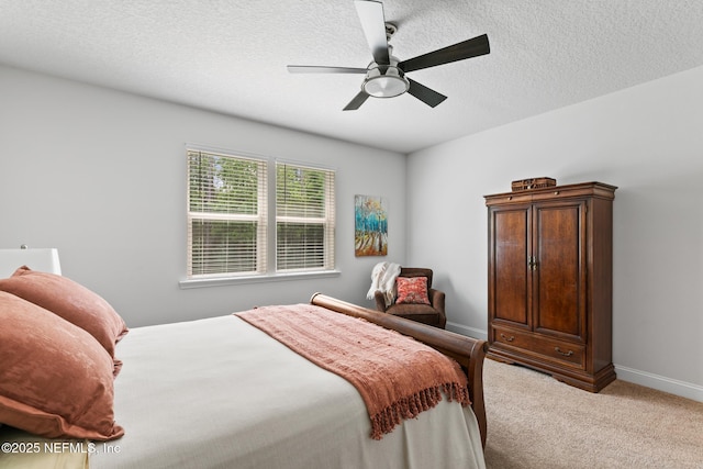 carpeted bedroom featuring a ceiling fan, baseboards, and a textured ceiling