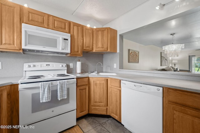 8550 A1A S Unit 340, Saint Augustine, FL 32080 - kitchen featuring white appliances, a sink, light countertops, a chandelier, and light tile patterned flooring