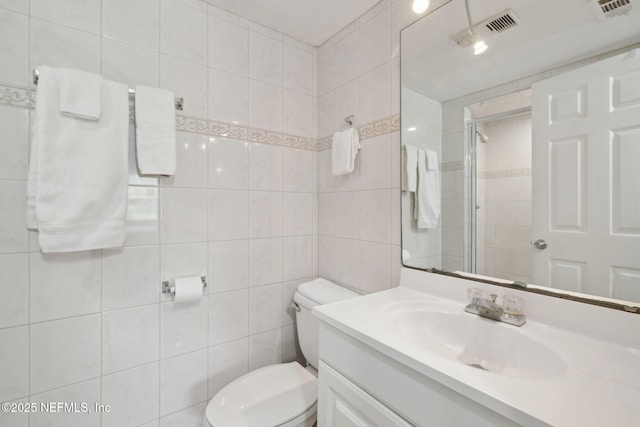 8550 A1A S Unit 340, Saint Augustine, FL 32080 - bathroom featuring toilet, vanity, a stall shower, and tile walls