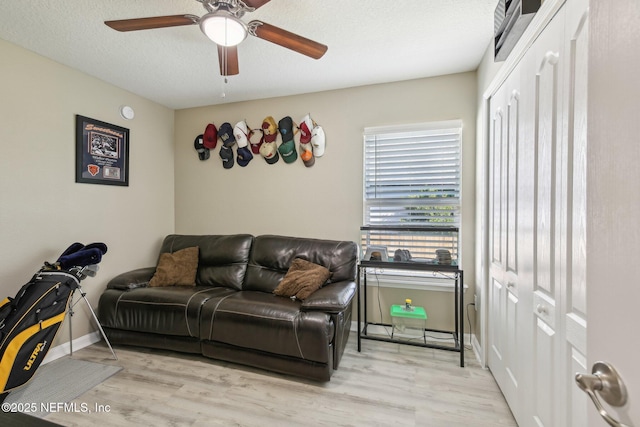 3228 Deer Creek Dr, Middleburg, FL 32068 - living room with light wood finished floors, a ceiling fan, baseboards, and a textured ceiling