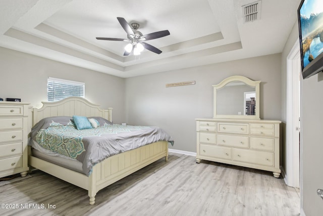 3228 Deer Creek Dr, Middleburg, FL 32068 - bedroom with a raised ceiling, light wood-type flooring, and a ceiling fan